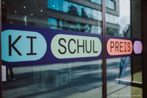 Logo-Aufkleber des KI-Schulpreises auf einer gläsernen Tür